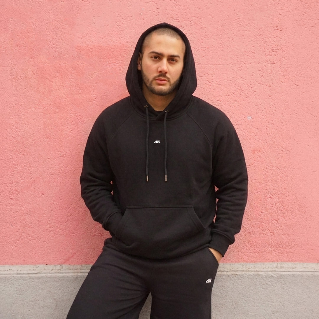 POLERÓN BOXY FIT NEGRO ALGODÓN HOMBRE - VISTA FRONTAL FONDO ROSA