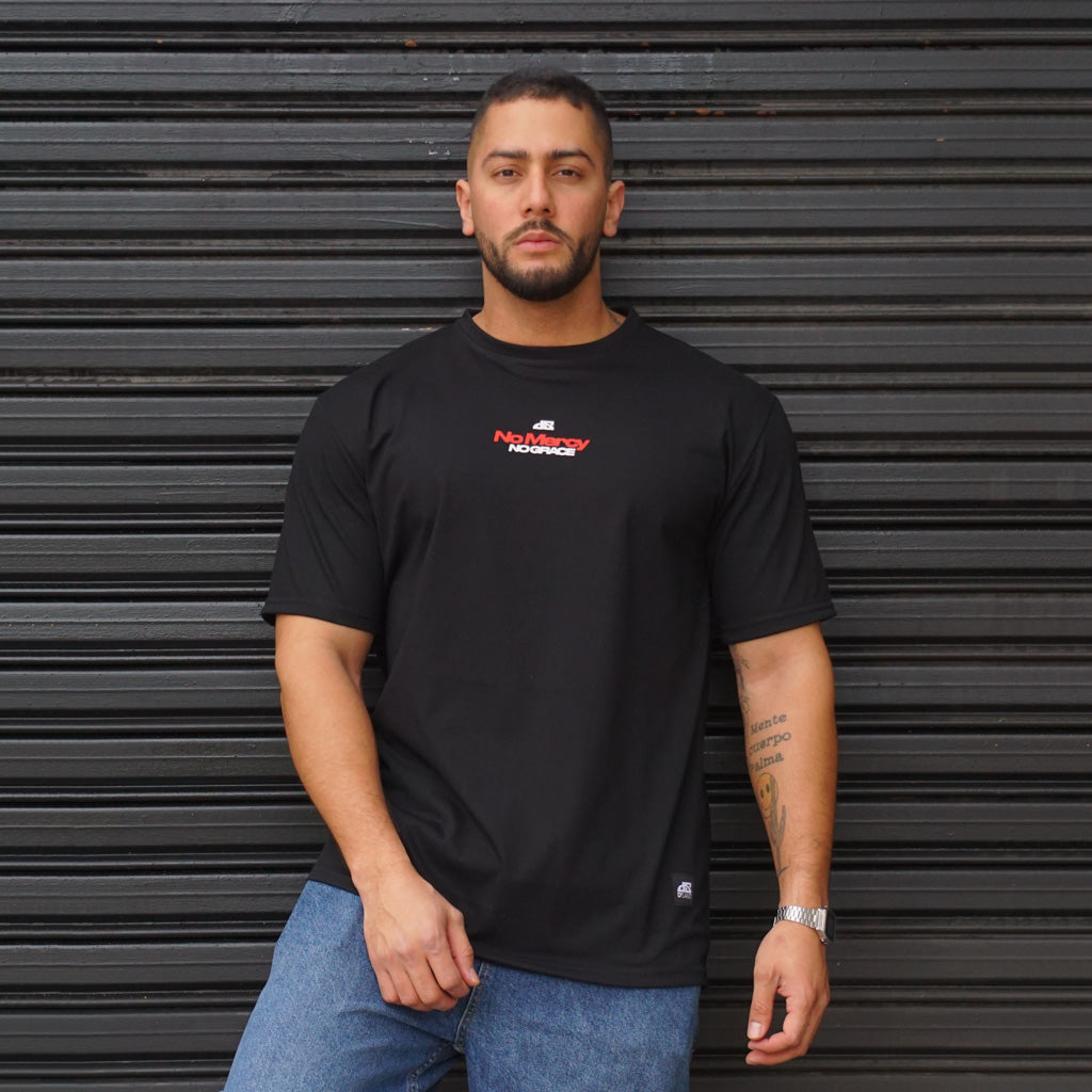 POLERA OVERSIZE NO MERCY NEGRA DSANTI 100 ALGODÓN 400 GRAMOS - VISTA RELAJADA EN MURO
